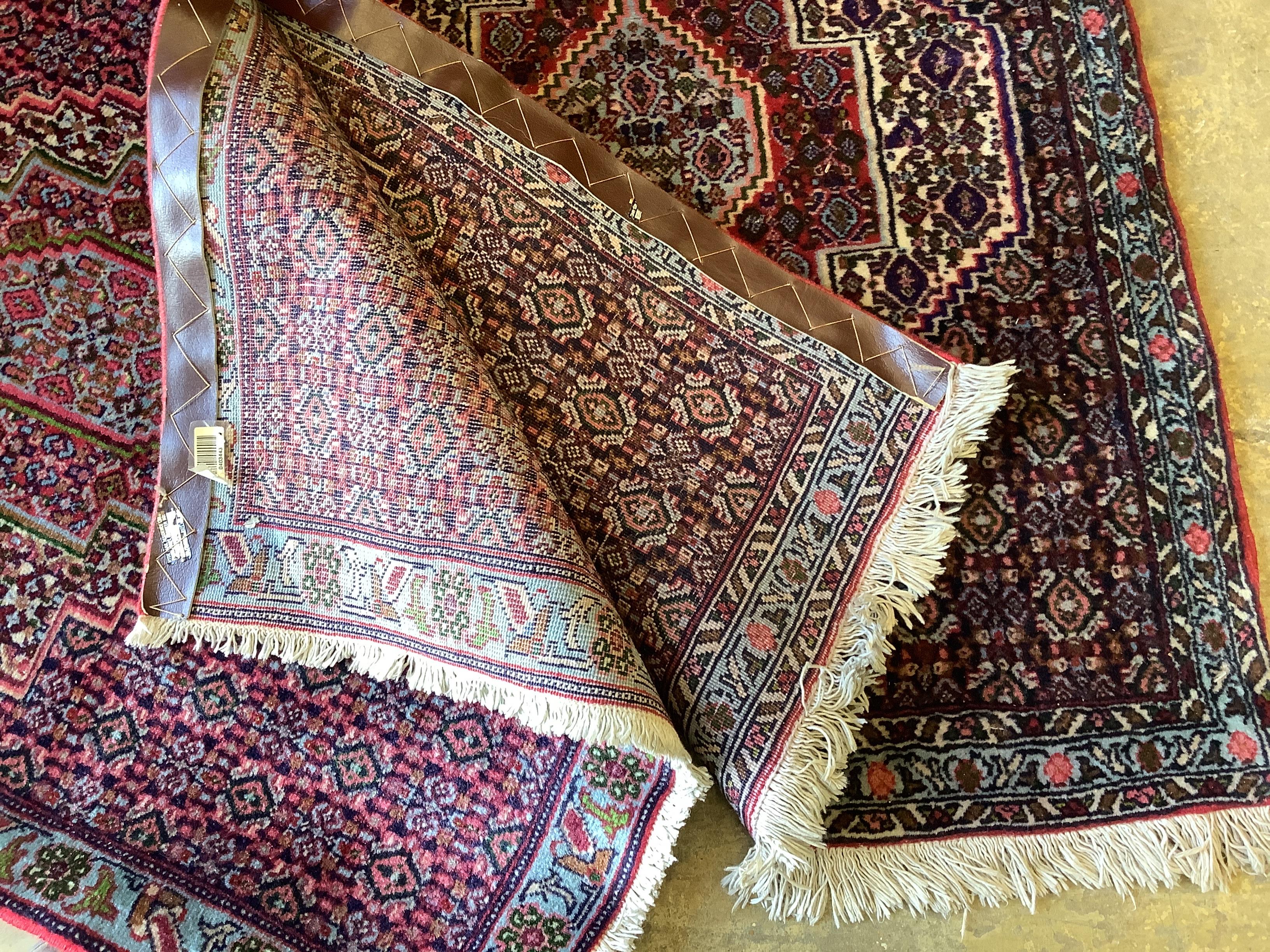 A near pair of Senneh blue ground mats, larger 104 x 77cm